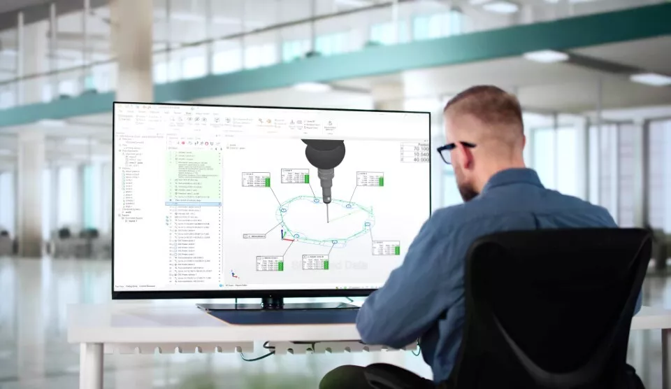 A metrologist leveraging PolyWorks|Inspector's no-code CMM programming workflow while viewing a 3D CAD model on a screen.
